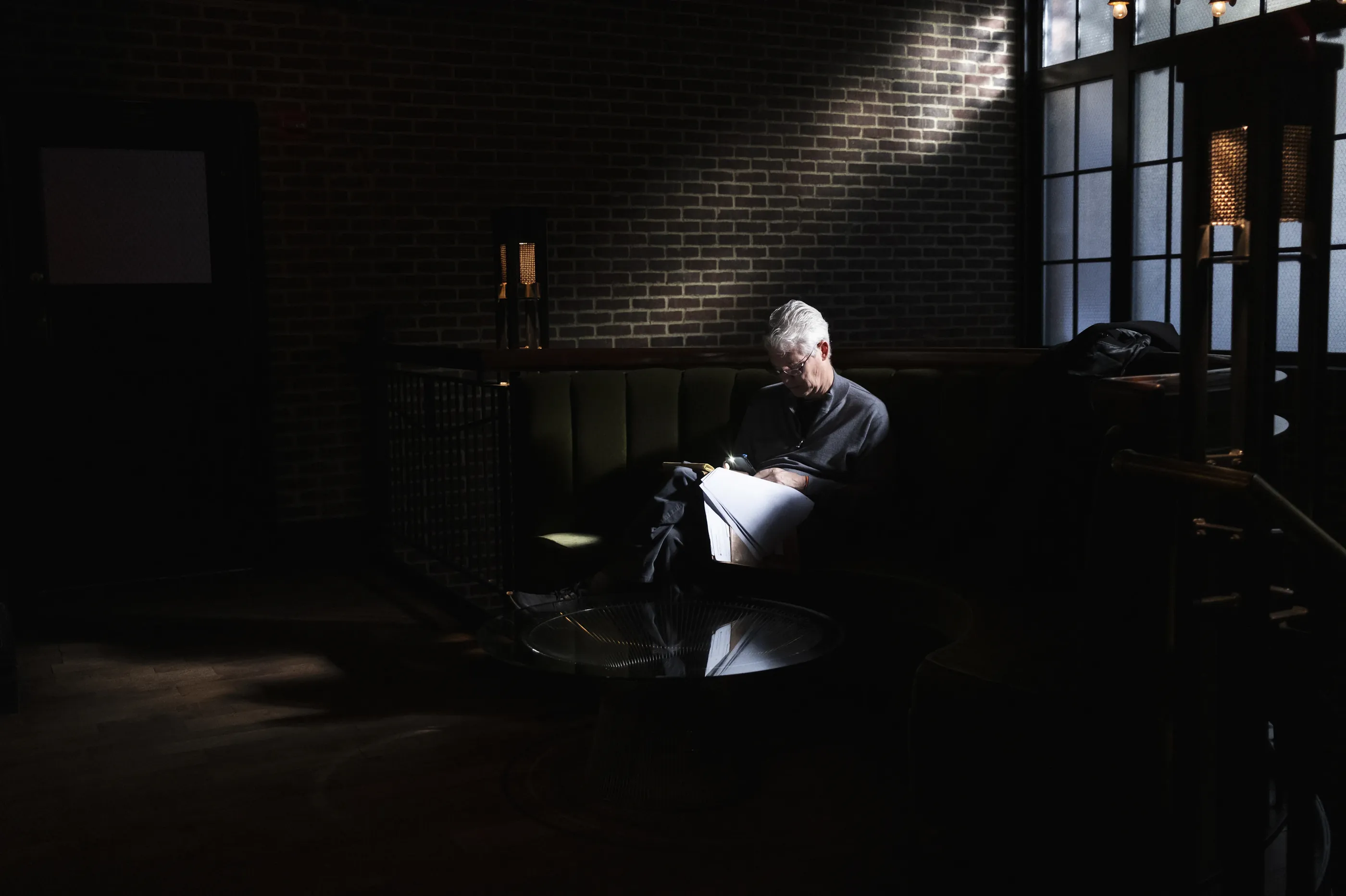 An attorney reading through papers in a quiet, dim office