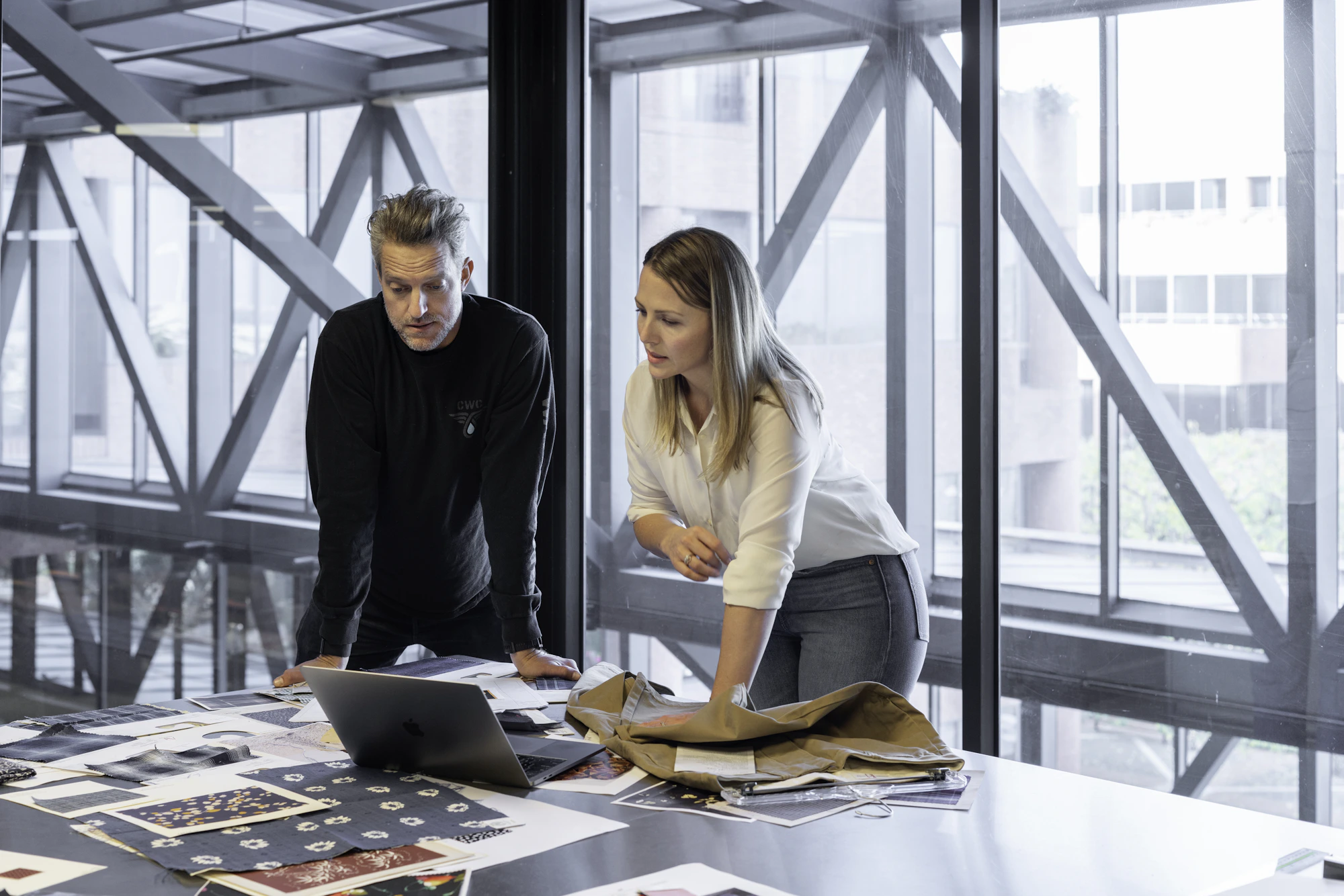 Two founders reviewing papers together at a studio table
