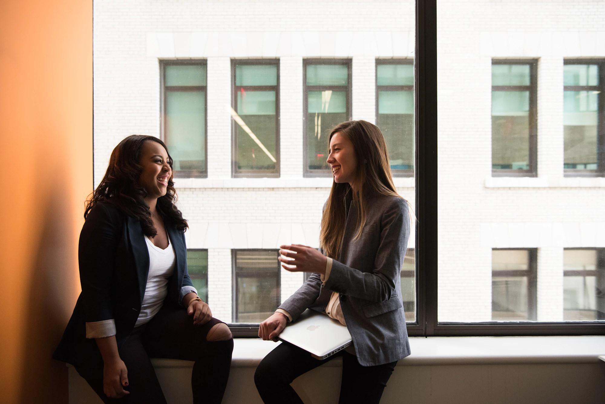 Two colleagues talking by an office window