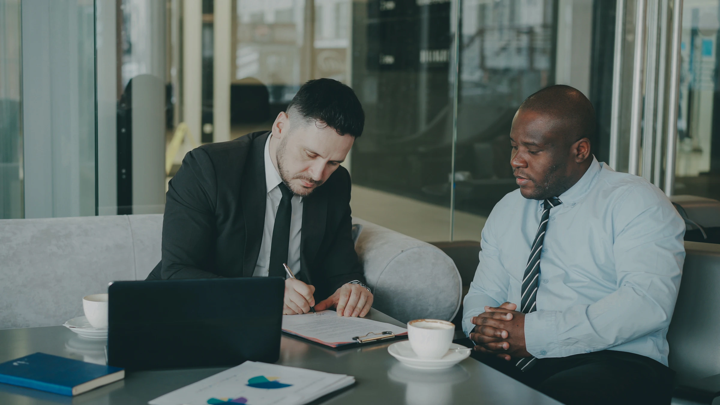 Two attorneys reviewing documents together over coffee